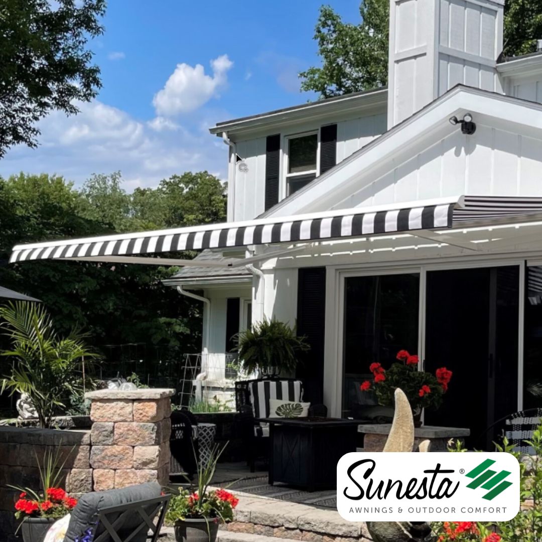 A striped Sunesta awning extended over a flower-lined patio