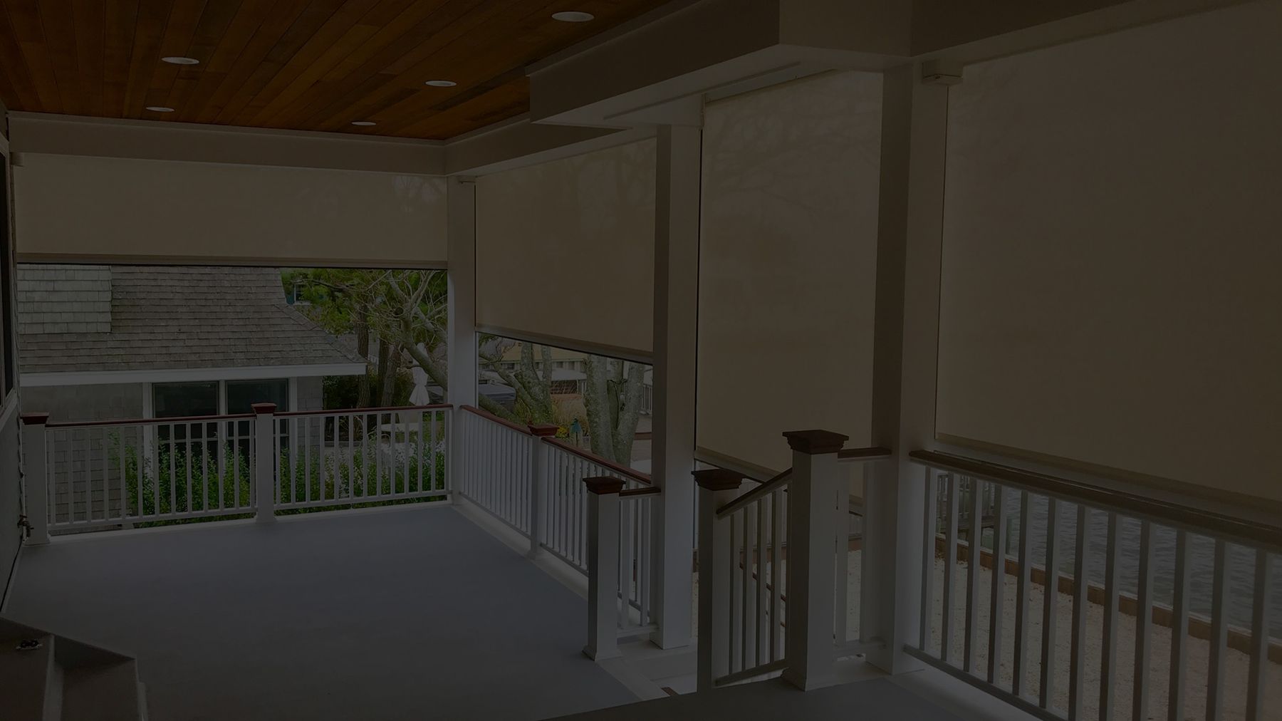 A lowered patio screen across a covered deck at dusk