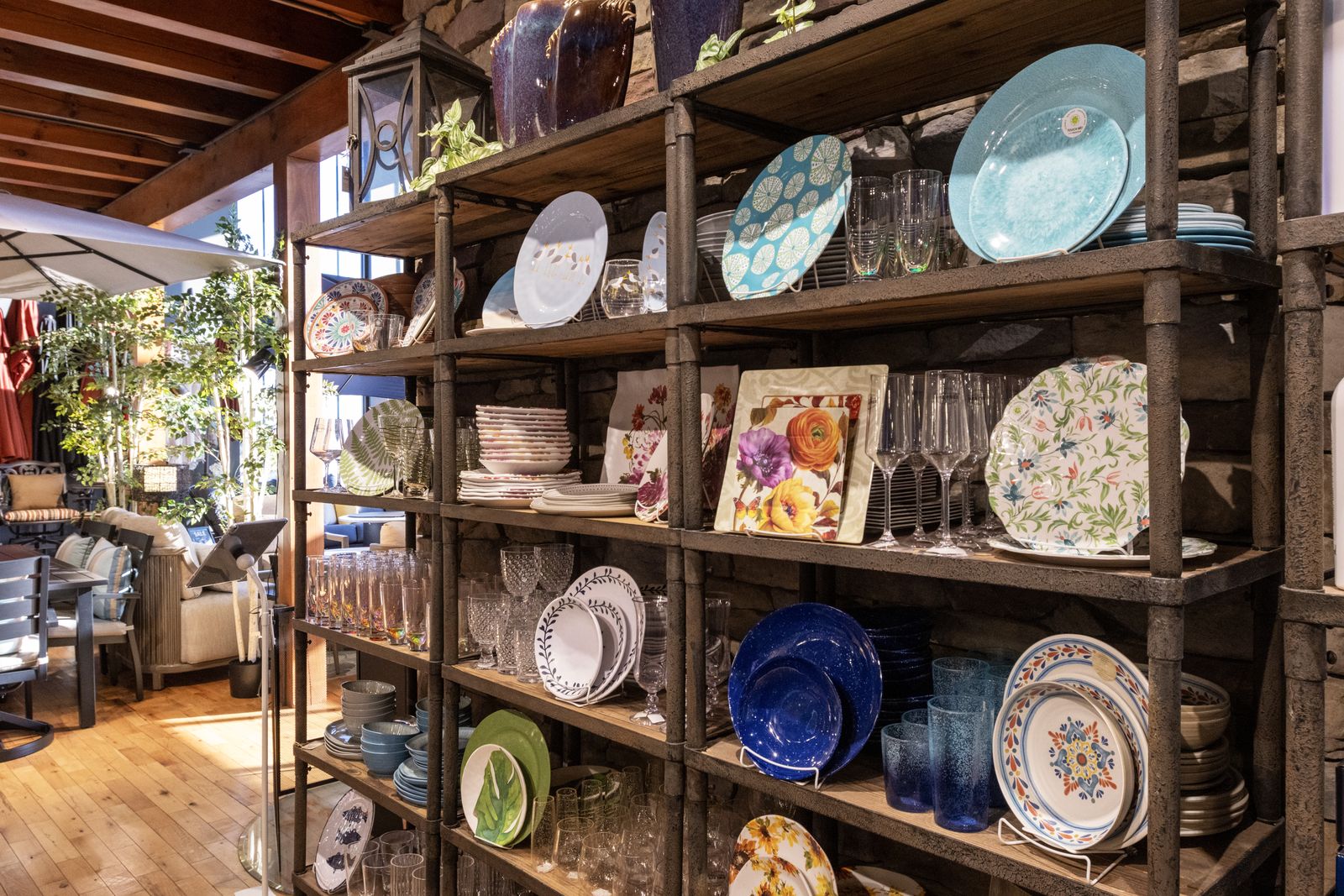 Shelves of outdoor melamine dinnerware, glassware, and serving pieces in the showroom