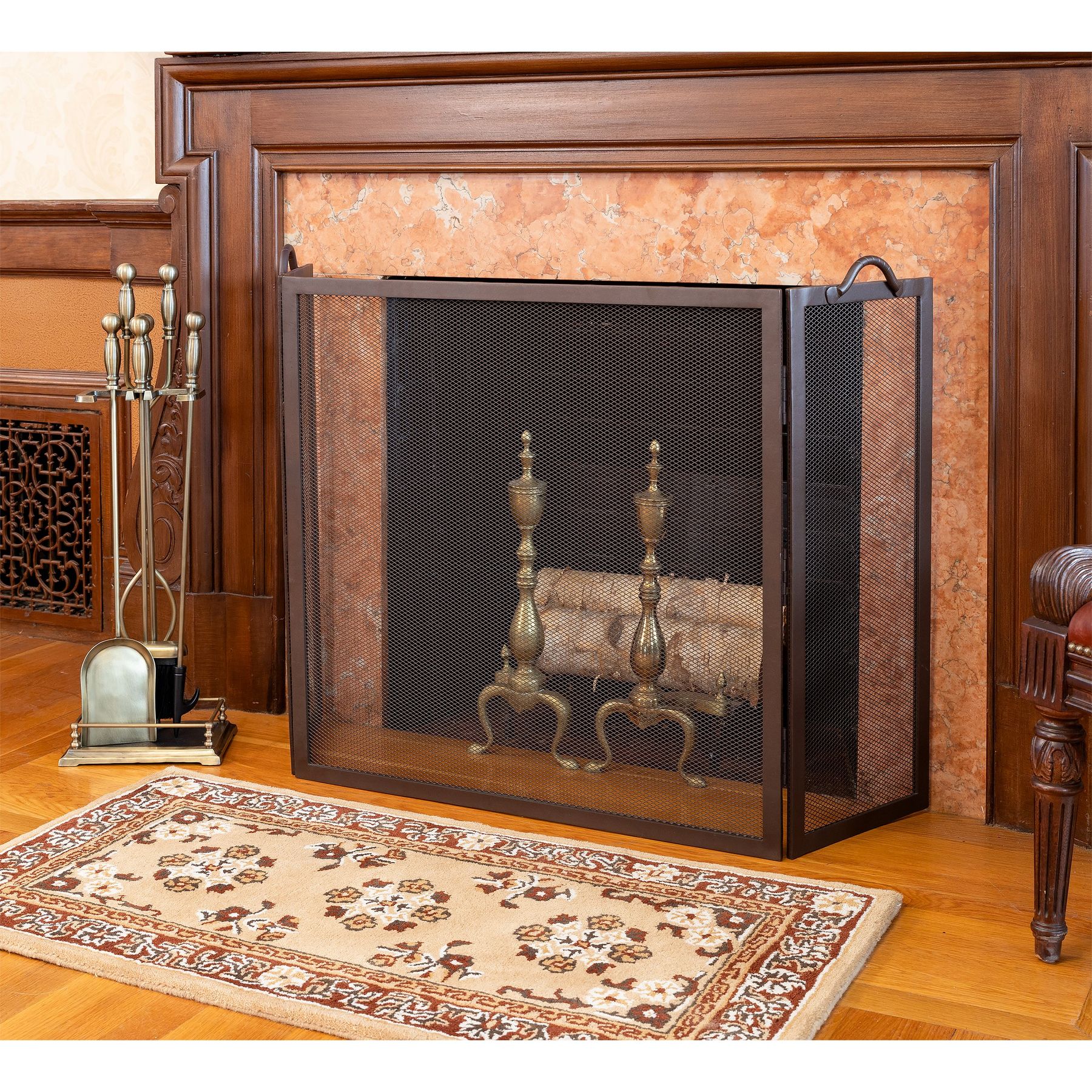 Paneled fireplace with a Minuteman Twisted Rope screen, andirons, tool set, and hearth rug