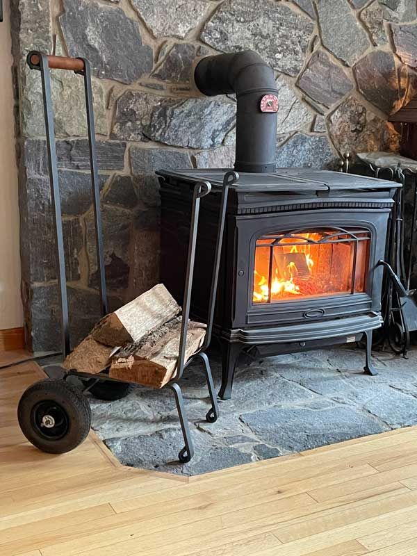 Pilgrim Big Wheel firewood cart next to a wood stove