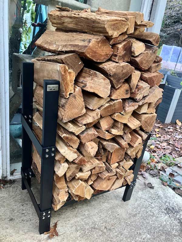 Pilgrim outdoor firewood rack stacked with split wood