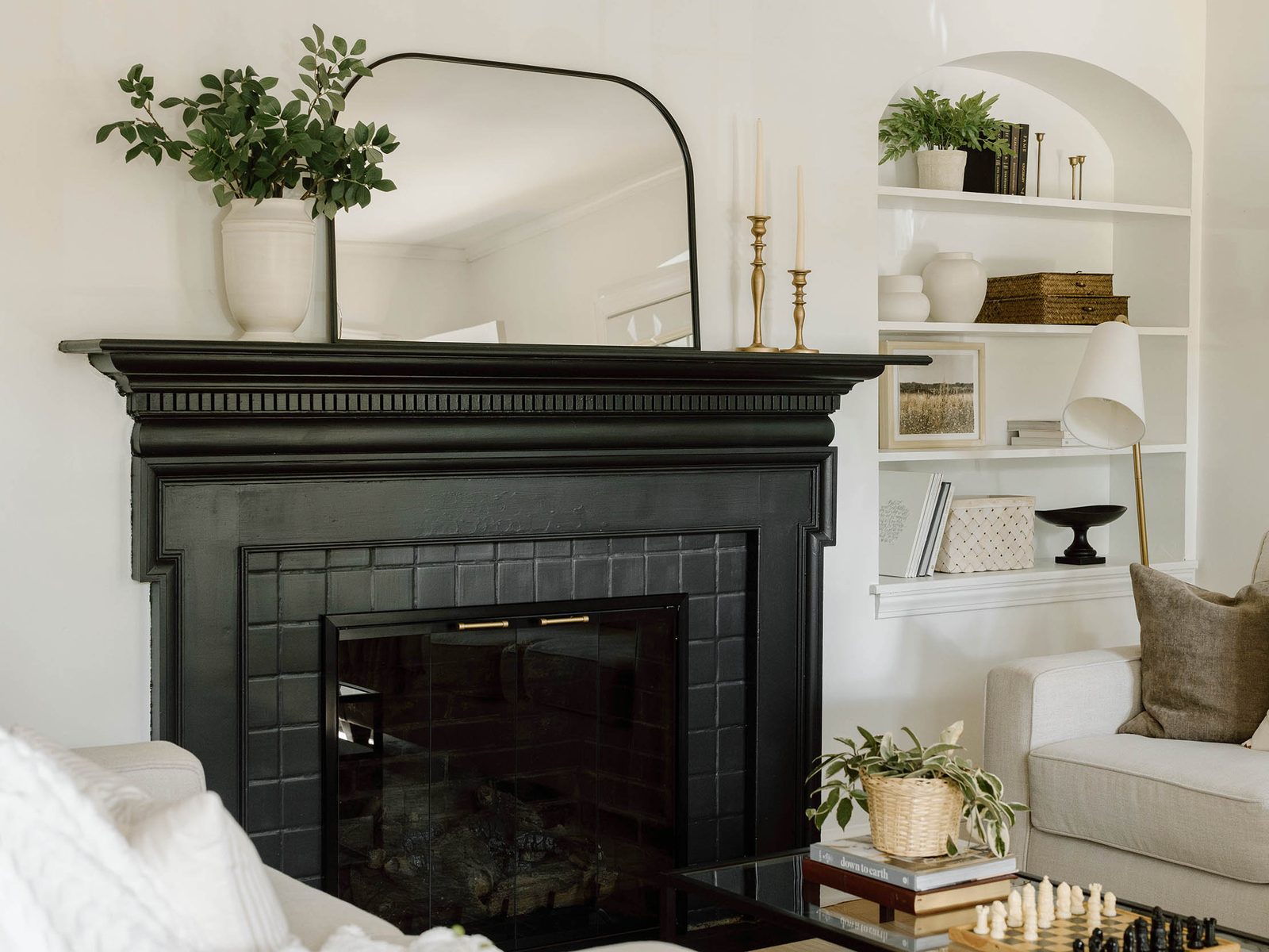 Black Stoll glass fireplace doors, closed, in a black-painted mantel and tile surround