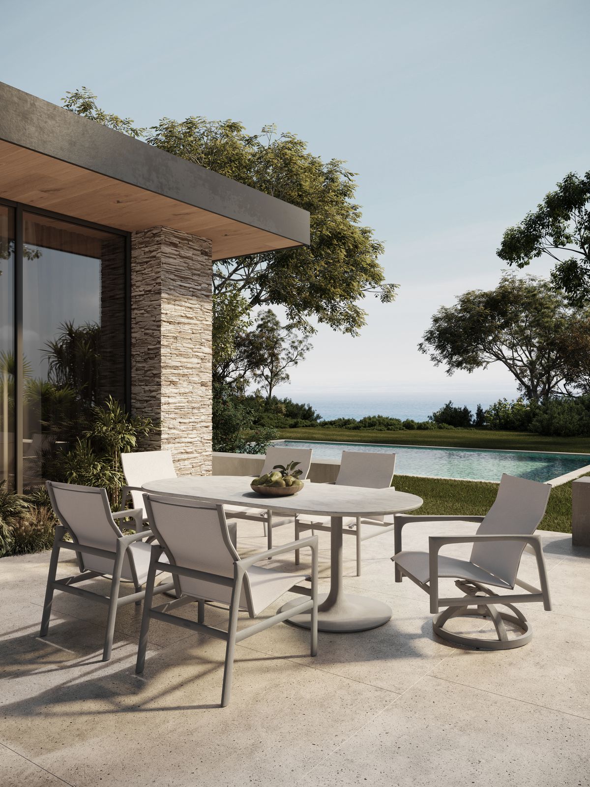 A cast-aluminum sling dining set beside a pool at golden hour