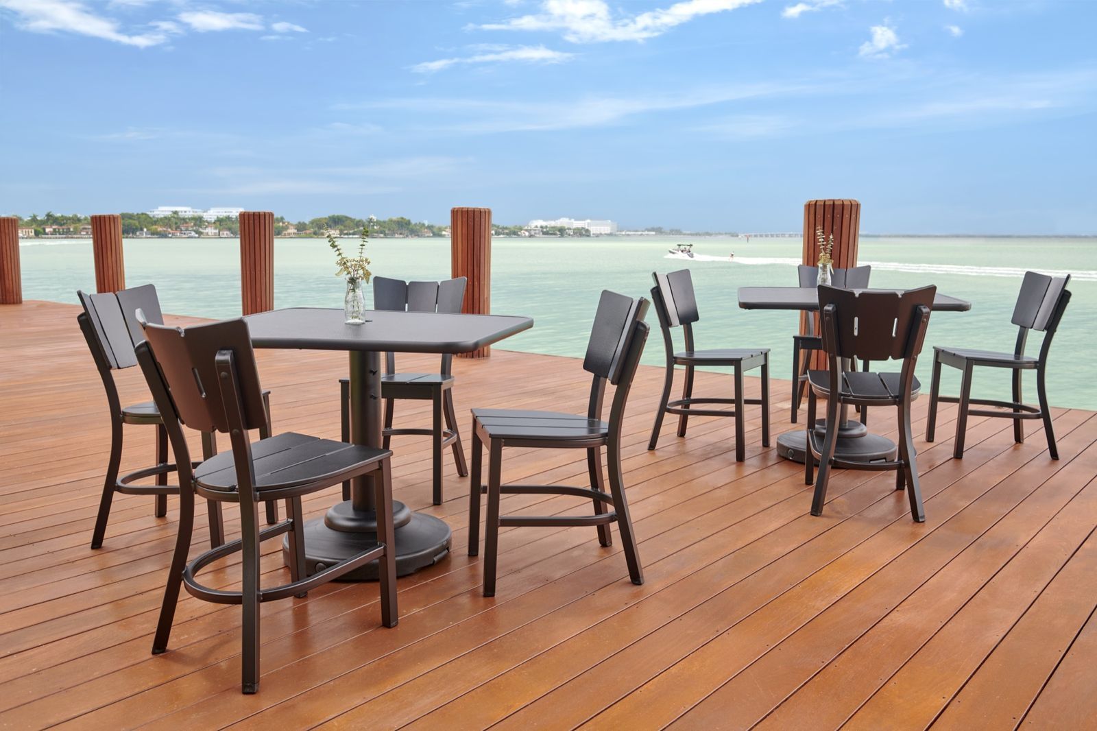A marine-grade polymer bar-height dining set on a waterfront dock